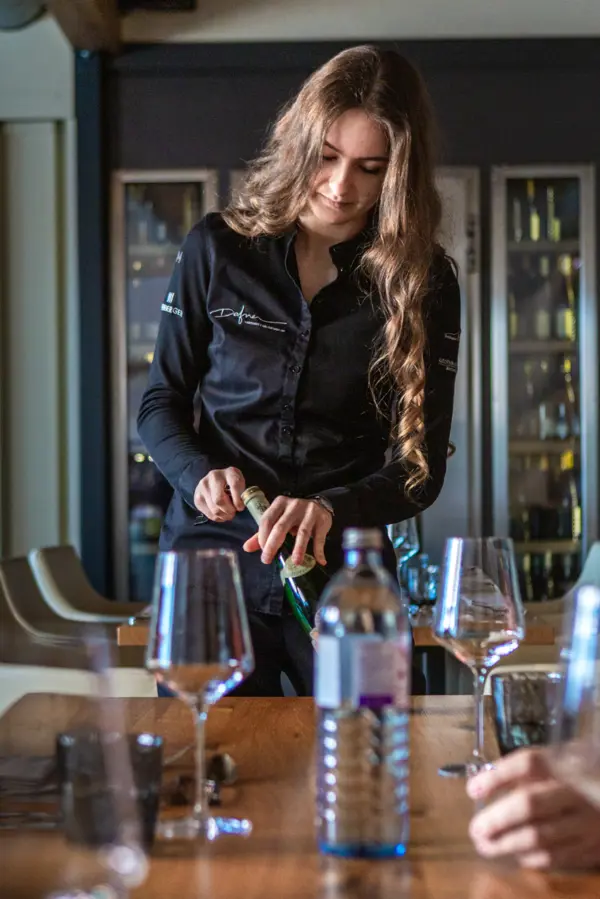 Wein wird von Kellnerin geöffnet